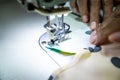 Seamstress sews. Clothes made on a sewing machine. Work by the light of the built-in hardware lamp Royalty Free Stock Photo