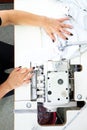 Sewing on a machine. Working woman sews on the sewing room sewing machine.