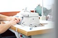 Sewing on a machine. Working woman sews on the sewing room sewing machine.