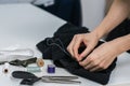 Seamstress is stitching zipper to black wide-leg pants Royalty Free Stock Photo