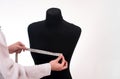 a seamstress takes measurements on a mannequin. the process of sewing fashionable clothes.  on a white Royalty Free Stock Photo