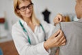 Seamstress takes measurements from woman, workshop Royalty Free Stock Photo