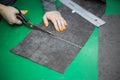 Woman's hand cuts a piece of fabric before sewing - scene with sewing tools: ruler, tailor inches, scissors, pattern and chalk