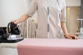 Seamstress woman steams iron cloth for sewing clothes