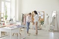 Seamstress in sewing workshop takes measurements of client to sew appropriate clothes. Royalty Free Stock Photo