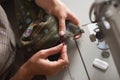 Seamstress working on modern electrical sewing machine making exclusive garments in fashion studio.