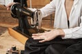 Seamstress working on new project. Female sewer working with fabric, creating fashionable garment with sewing machine in Royalty Free Stock Photo