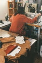 seamstress working with sewing machine in tailor shop with leather sheets