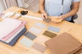 Seamstress young woman selects color layout for choosing fabrics and sewing clothes