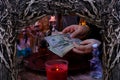 Seance in salon of soothsayer, female hands of psychic doing witchcraft passes with money, esoteric Oracle performs ritual of