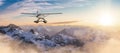 Seaplane flying over the Rocky Mountains during a colorful sunset.