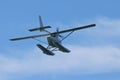 Seaplane hydroplane or floatplane flying in blue sky closeup. Cabin, wings propeller, engine, tail of plane are visible in detai