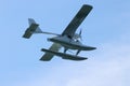 Seaplane hydroplane or floatplane flying in blue sky closeup. Cabin, wings propeller, engine, tail of plane are visible in detai