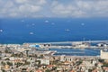 Seaport in the city of Haifa, panorama of the port and city buildings against the background of a blue sky with clouds.