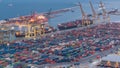 Seaport and loading docks at the port with cranes and multi-colored cargo containers day to night Royalty Free Stock Photo