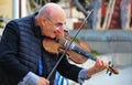 Seaport Village, San Diego, California - January 2016: Smiling elderly gentleman plays the violin for passers by