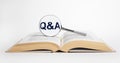 Search for answers to questions in books. Magnifying glass with qa abbreviation. Reading as source of knowledge concept Royalty Free Stock Photo