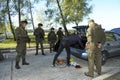 Search at the checkpoint, military training. Man pulls his personal belongings out from a car, soldiers stand around watching