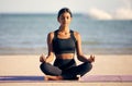 On the search for inner peace. Full length shot of an attractive young woman meditating on the beach. Royalty Free Stock Photo