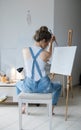 In search of inspiration. Sad Woman painter in front of the canvas and drawing. Artist studio interior. Process in art workshop. Royalty Free Stock Photo