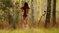 Search with a metal detector. Young woman digging detected metal in the forest