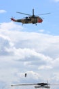 Search and Rescue helicopter hoists two men up Royalty Free Stock Photo