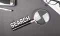 Search wiriting on black office desk with magnify glass Royalty Free Stock Photo