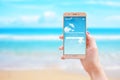 Search your next holiday travel app on smart phone in woman hand