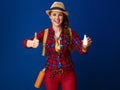 Woman hiker isolated on blue with nasal drops showing thumbs up