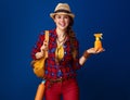 Happy fit woman hiker isolated on blue background showing SPF