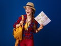 Happy traveller woman isolated on blue background with map Royalty Free Stock Photo