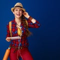 Woman hiker isolated on blue background listening to music