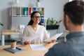 Searching for job. Human resources manager speaking to employment applicant on work interview, holding CV at office Royalty Free Stock Photo