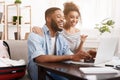 Searching tour. African-american couple using laptop at home Royalty Free Stock Photo