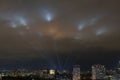 Searchlights shine in the night sky over the city