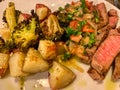 seared beef steak, baked potatoes and vegetable salad