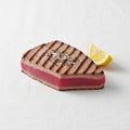 A seared tuna steak with grilled marks is centered on a white Royalty Free Stock Photo