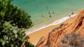 Seascape at Albufeira Portugal with people swimming surrounded by greenery