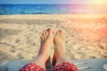 Seascape on the background of the female foot. A woman in a red dress near the water by the ocean. The girl lies on the yellow Royalty Free Stock Photo