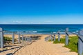 Seascape of beach entrance with wooden rails and sand shore Royalty Free Stock Photo