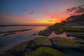 Seascape. Beach with rocks and stones. Low tide. Pink sunset. Slow shutter speed. Soft focus. Melasti beach, Bali, Indonesia Royalty Free Stock Photo