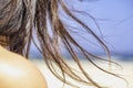 Seascape, beach and woman`s hair. Girl and her long naughty hair on the strong wind.