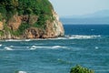 Seascape, beautiful view of the rocky cliff in the sea with mountains on the horizon Royalty Free Stock Photo