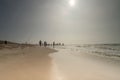 Seascape with blurred people walking in the background. Silhouette of people on the beach and in the sea, people fishing