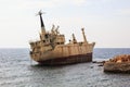 Seascape: boat EDRO III shipwrecked near the rocky shore at the sunset. Mediterranean, near Paphos. Cyprus Royalty Free Stock Photo