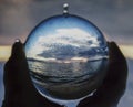 Seascape Captured in Glass Ball Held in Hand Royalty Free Stock Photo