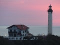 Seascape with before a traditional house and a white lighthouse on sunset to Biarritz in France. Royalty Free Stock Photo