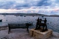 A seascape with a cloudy sky and a bench and an old boat winch in the foreground Royalty Free Stock Photo
