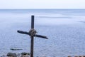 Seascape with cross of sticks on rocky beach in overcast day, closeup. Royalty Free Stock Photo