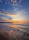 Seascape dawn scene, natural vertical background. Early morning on the beach with a peaceful view to the sunrise above the hills. Royalty Free Stock Photo